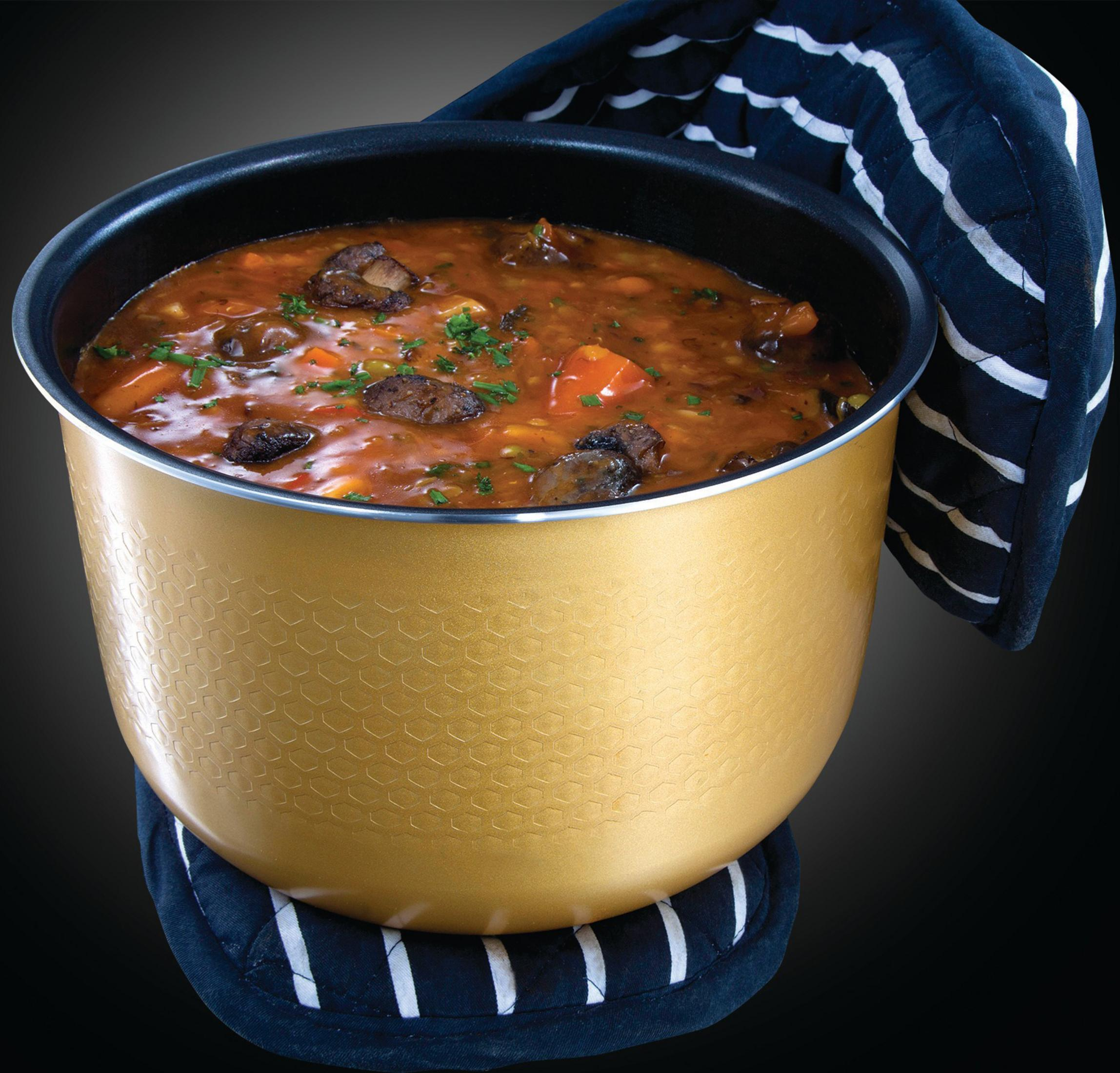 Casserole dorée avec ragoût copieux, garnie d'herbes, sur fond noir.