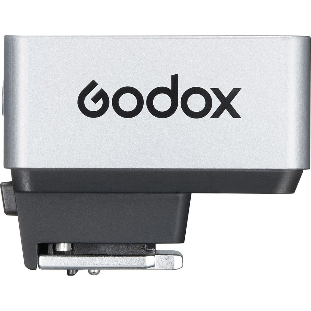 Émetteur flash Godox argenté avec boîtier noir et pied métallique.