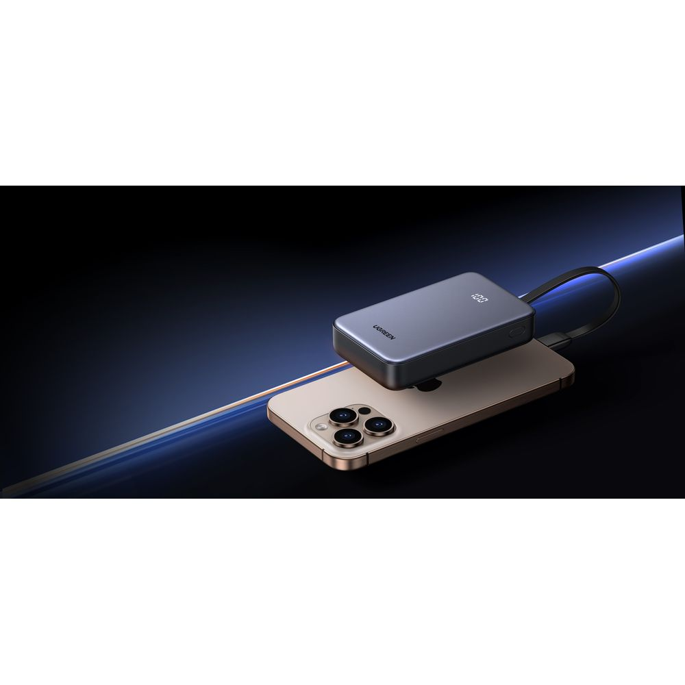 Szara powerbank z 100% naładowania podłączona do złotego smartfona.