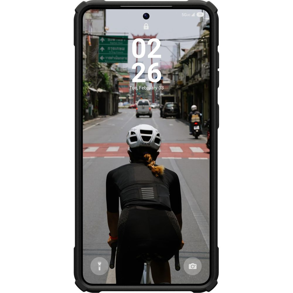 Radfahrerin mit Helm fährt auf einer Straße in einer Stadt. Verkehr, Gebäude.