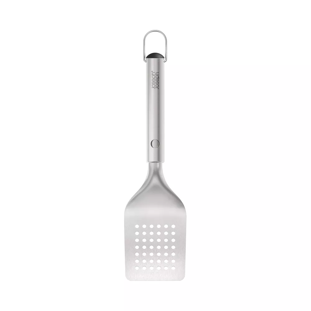 Una espátula plateada para parrilla con cabeza rectangular y perforada y mango colgante.