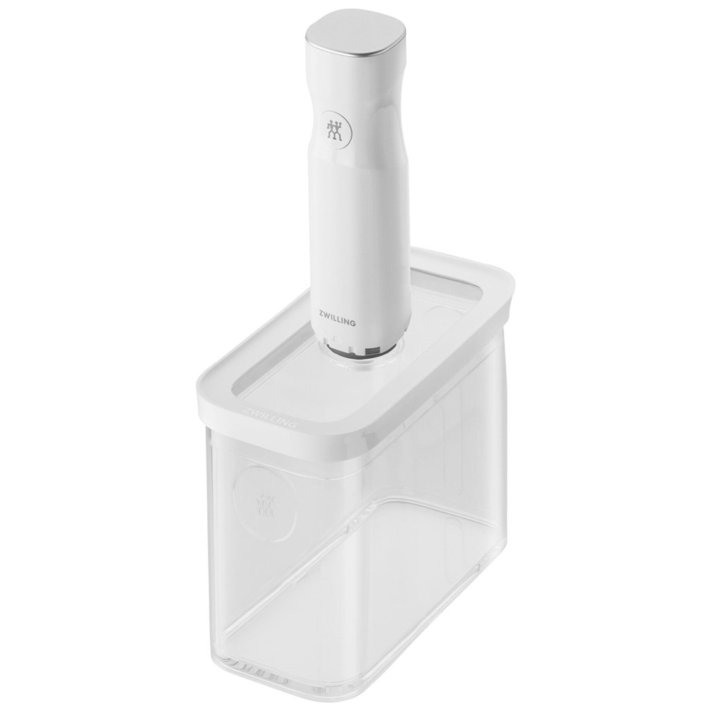 Un sellador al vacío blanco con tapa plateada se asienta sobre un recipiente transparente.