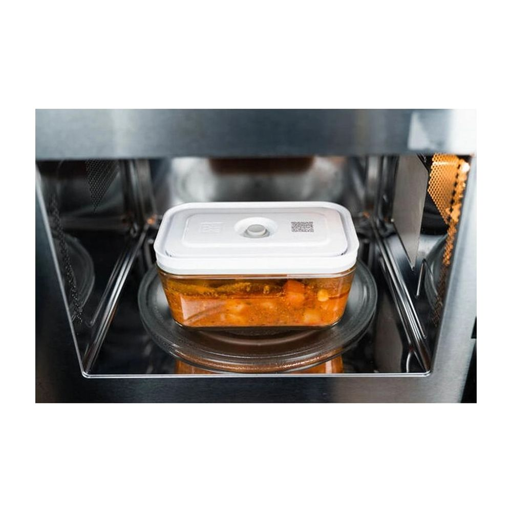 Un recipiente con comida dentro de un horno microondas.