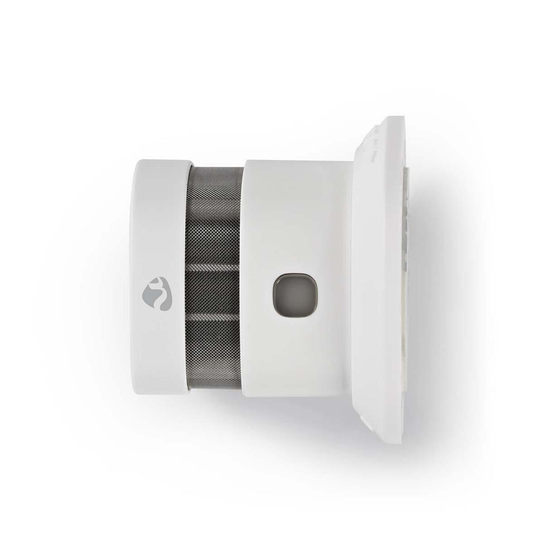 Detector de humo blanco con botón gris y rejilla de malla.