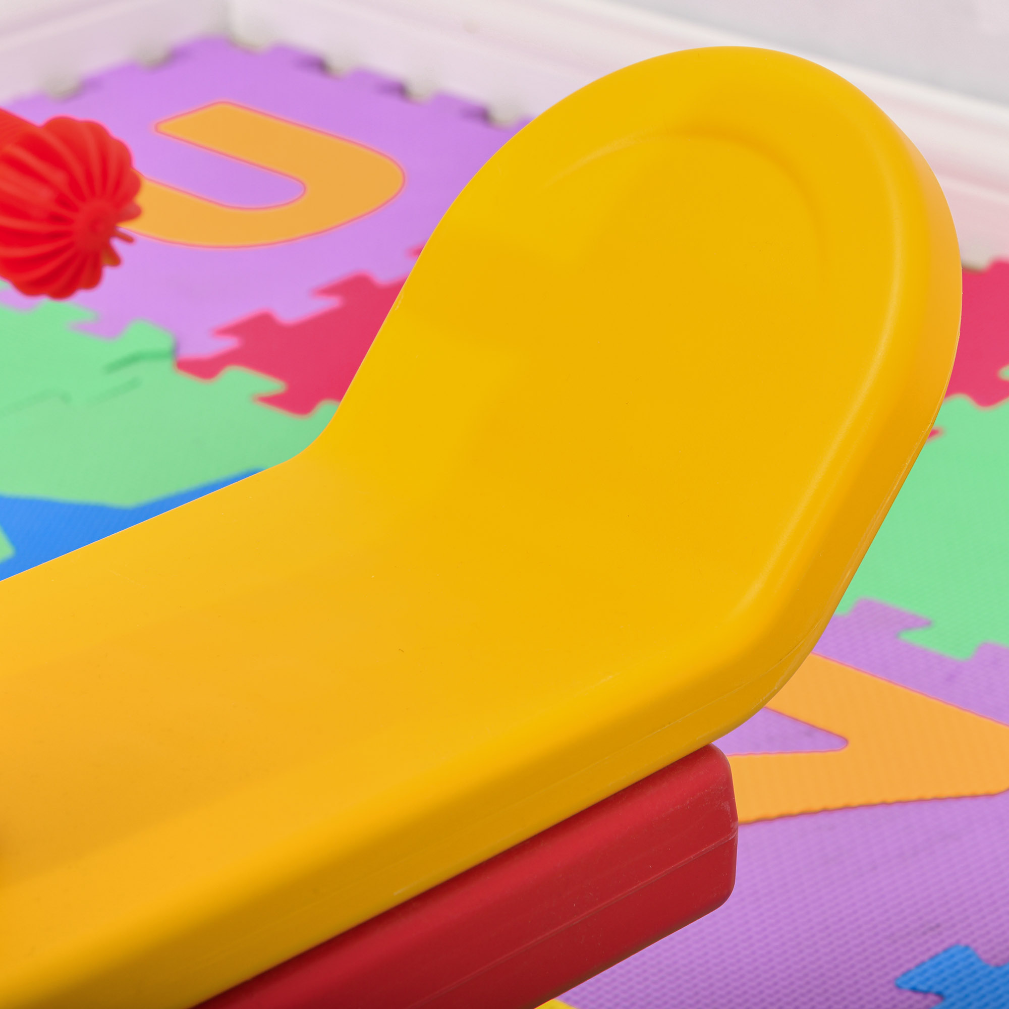 Un juguete amarillo descansa sobre una alfombra de letras.