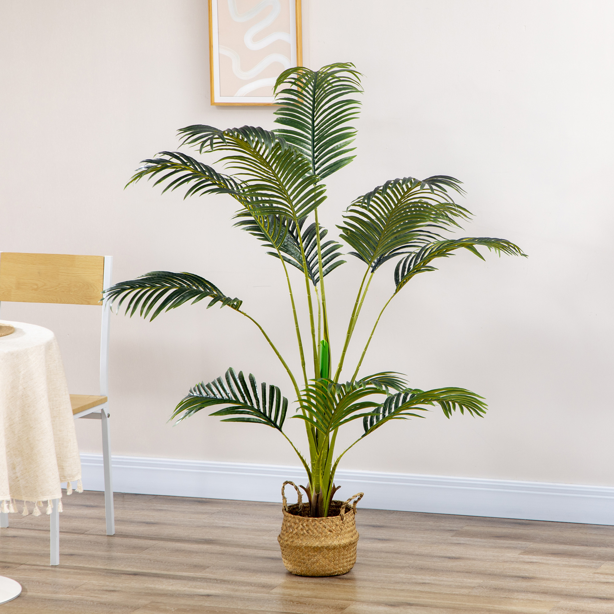 Una gran palmera artificial verde en una cesta tejida se alza sobre un suelo de madera.