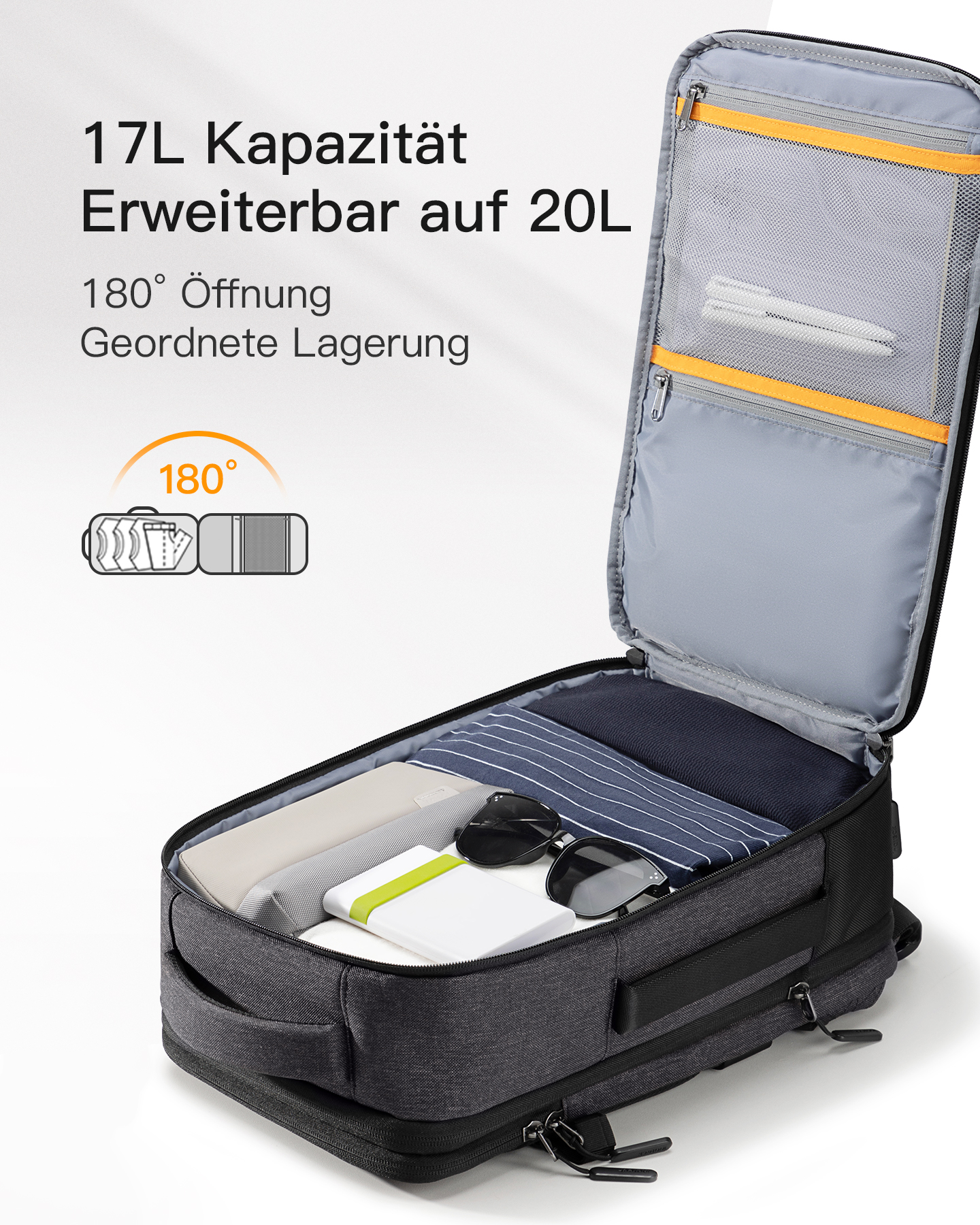 Offener Rucksack mit Kleidung, Sonnenbrille und Powerbank im Inneren.