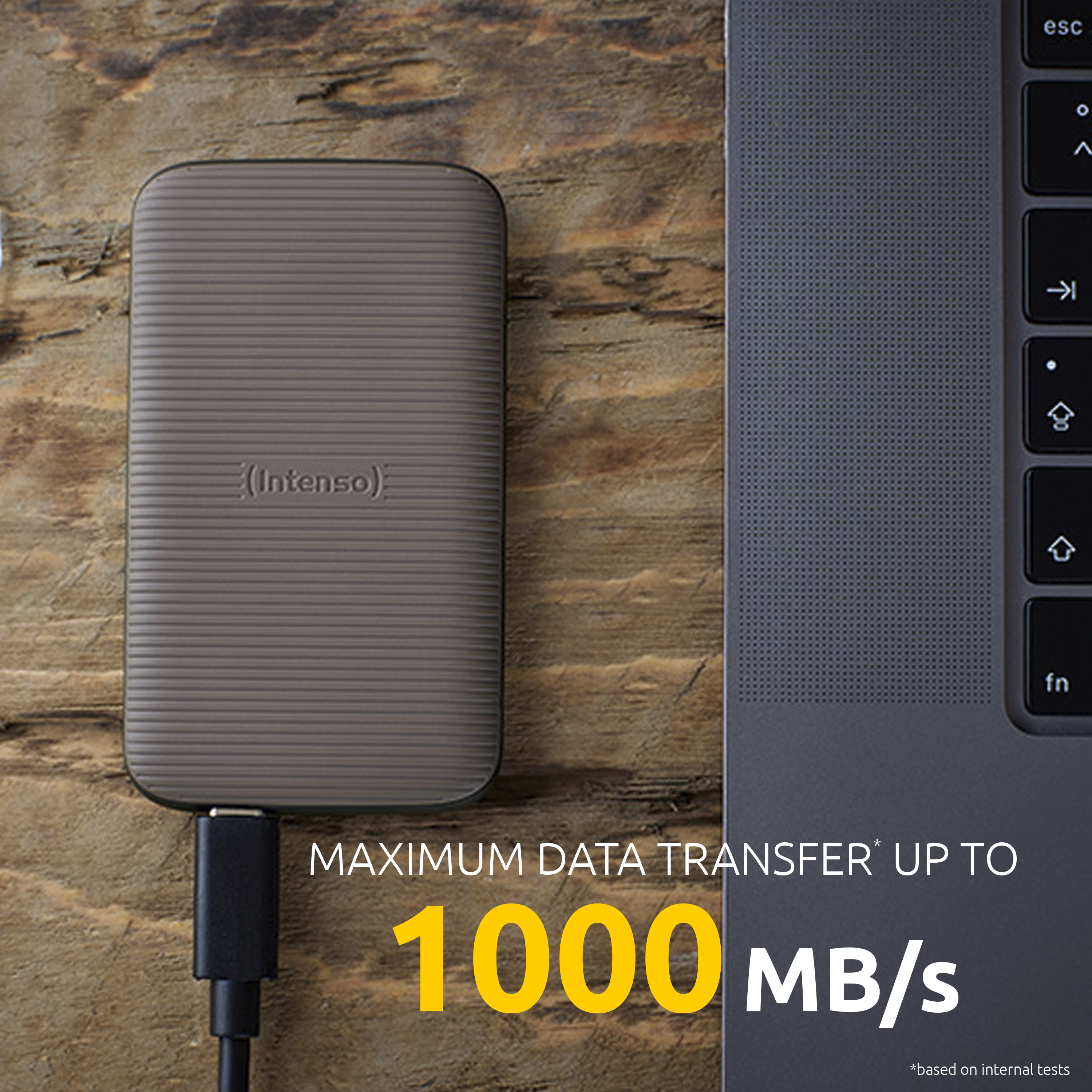 Dysk zewnętrzny podłączony do laptopa, prędkość transferu 1000 MB/s.