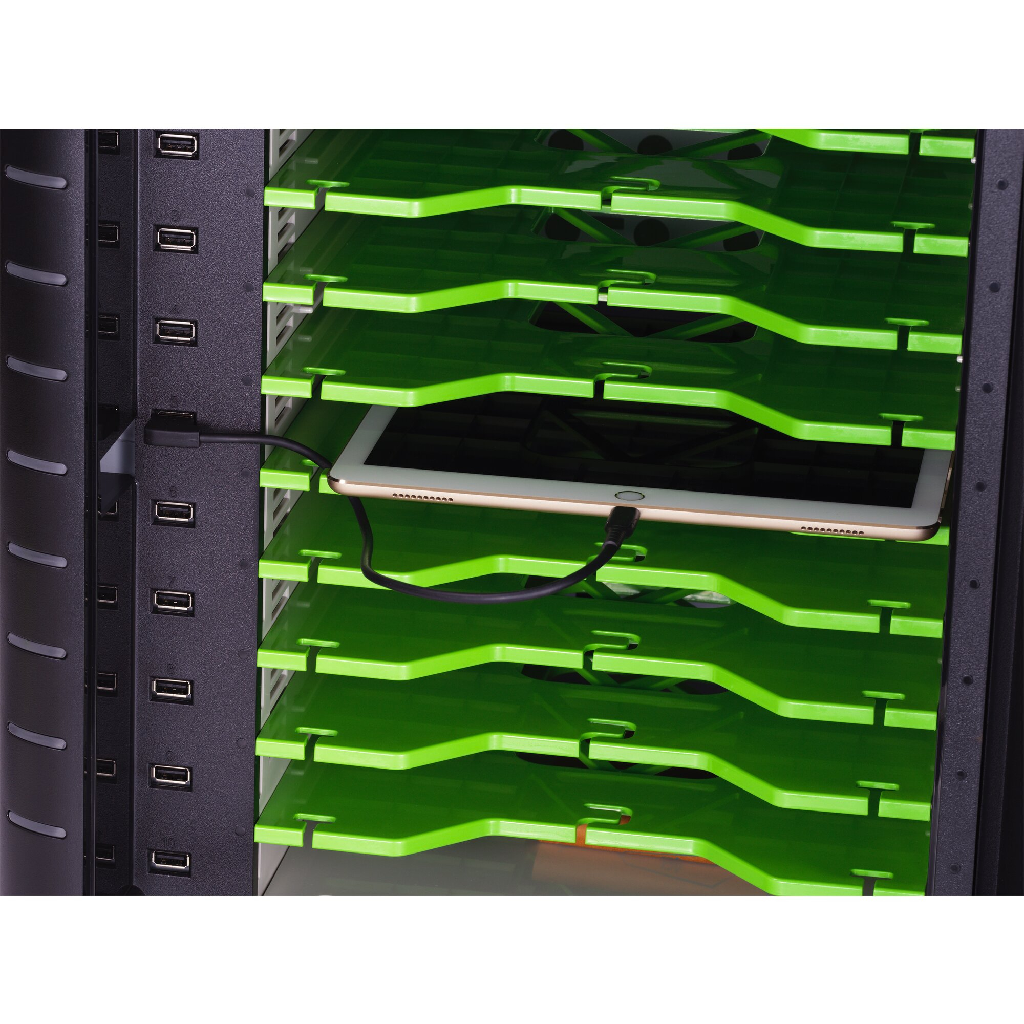 Tablet ładuje się w zielonym stojaku z portami USB.