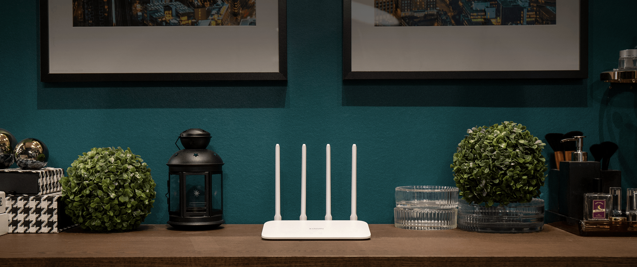Biały router z antenkami na drewnianym stole z dekoracjami.