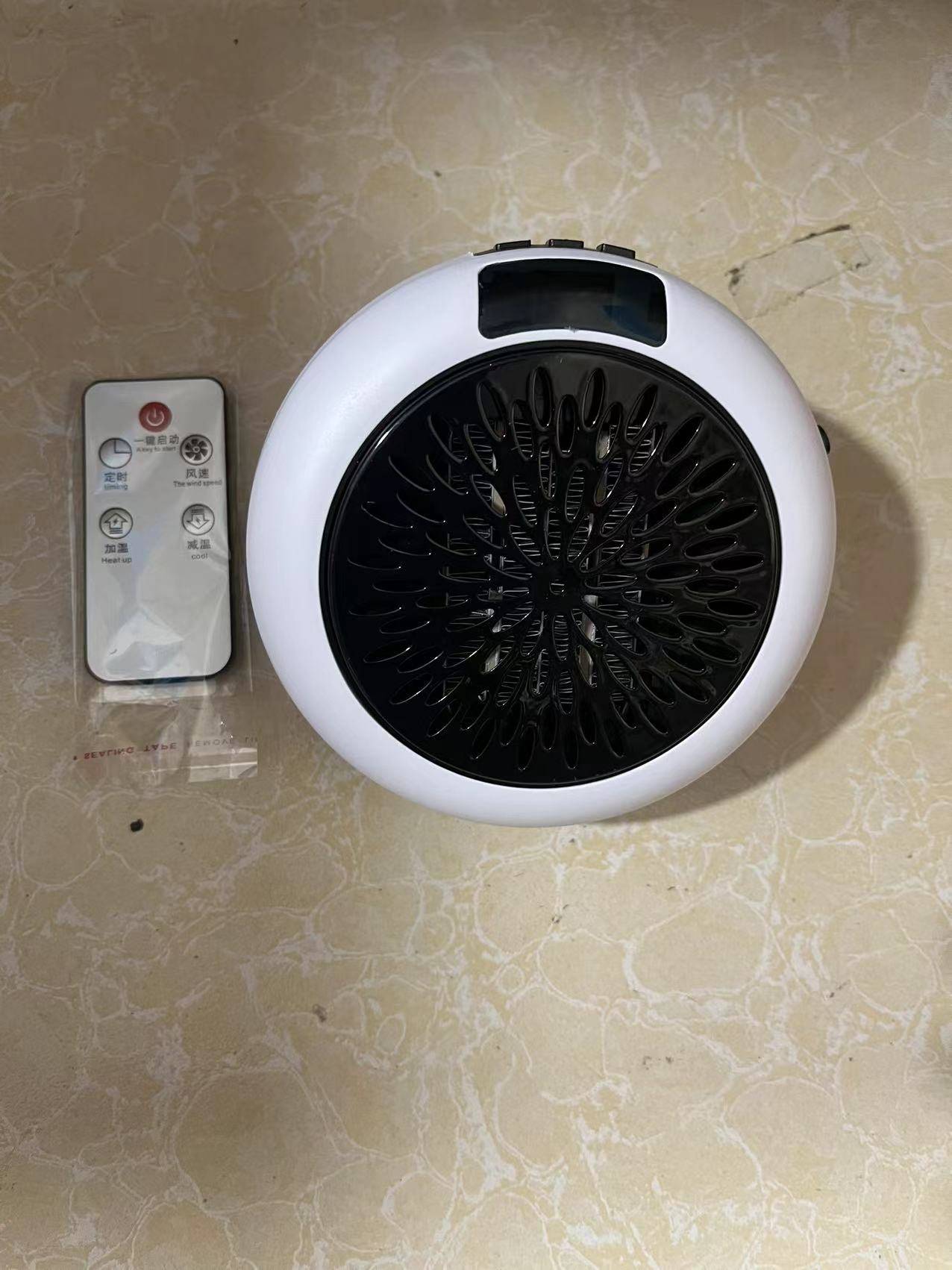 Ein weißer Heizlüfter mit schwarzem Lüftergitter und Fernbedienung liegen daneben.