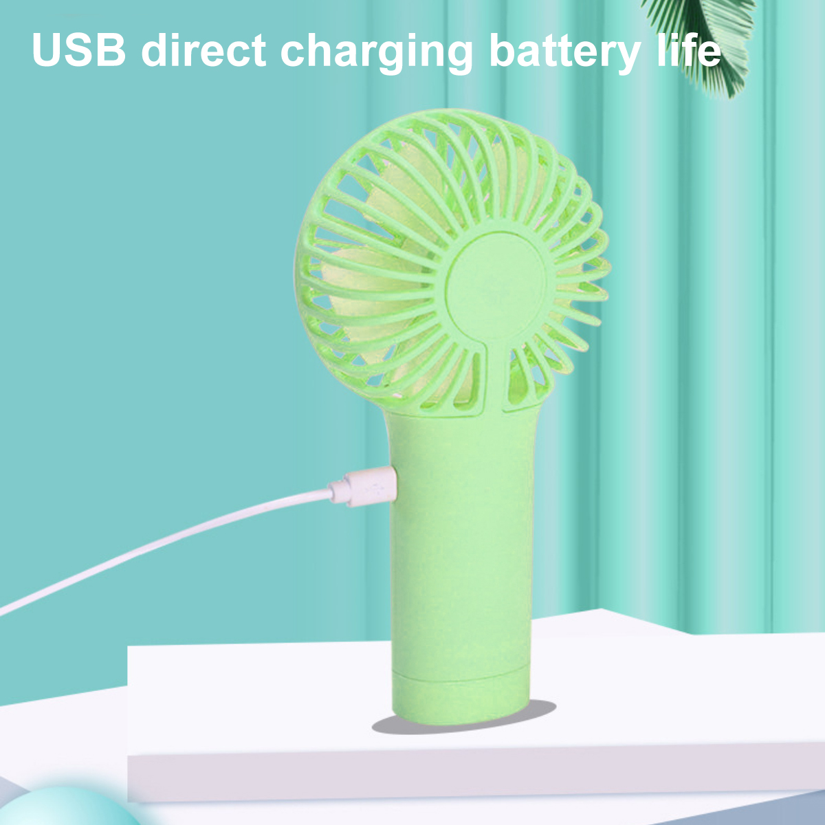 Ein hellgrüner Handventilator mit eingestecktem USB-Ladekabel.