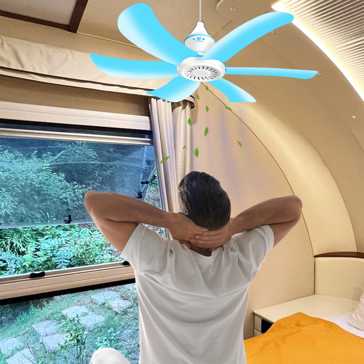 Ein Mann im weißen T-Shirt entspannt sich unter einem blauen Deckenventilator.