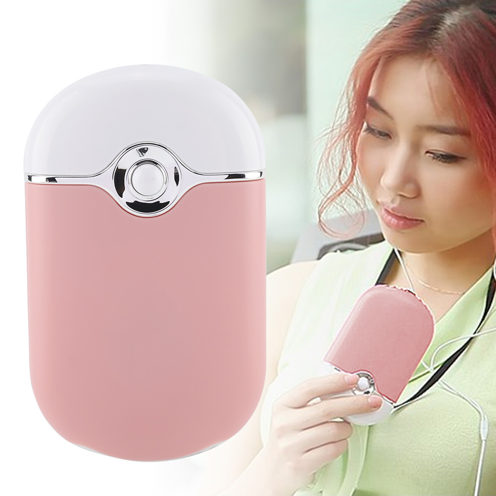 Ein rosafarbener Mini-Handventilator mit weißem Oberteil, gehalten von einer Frau.