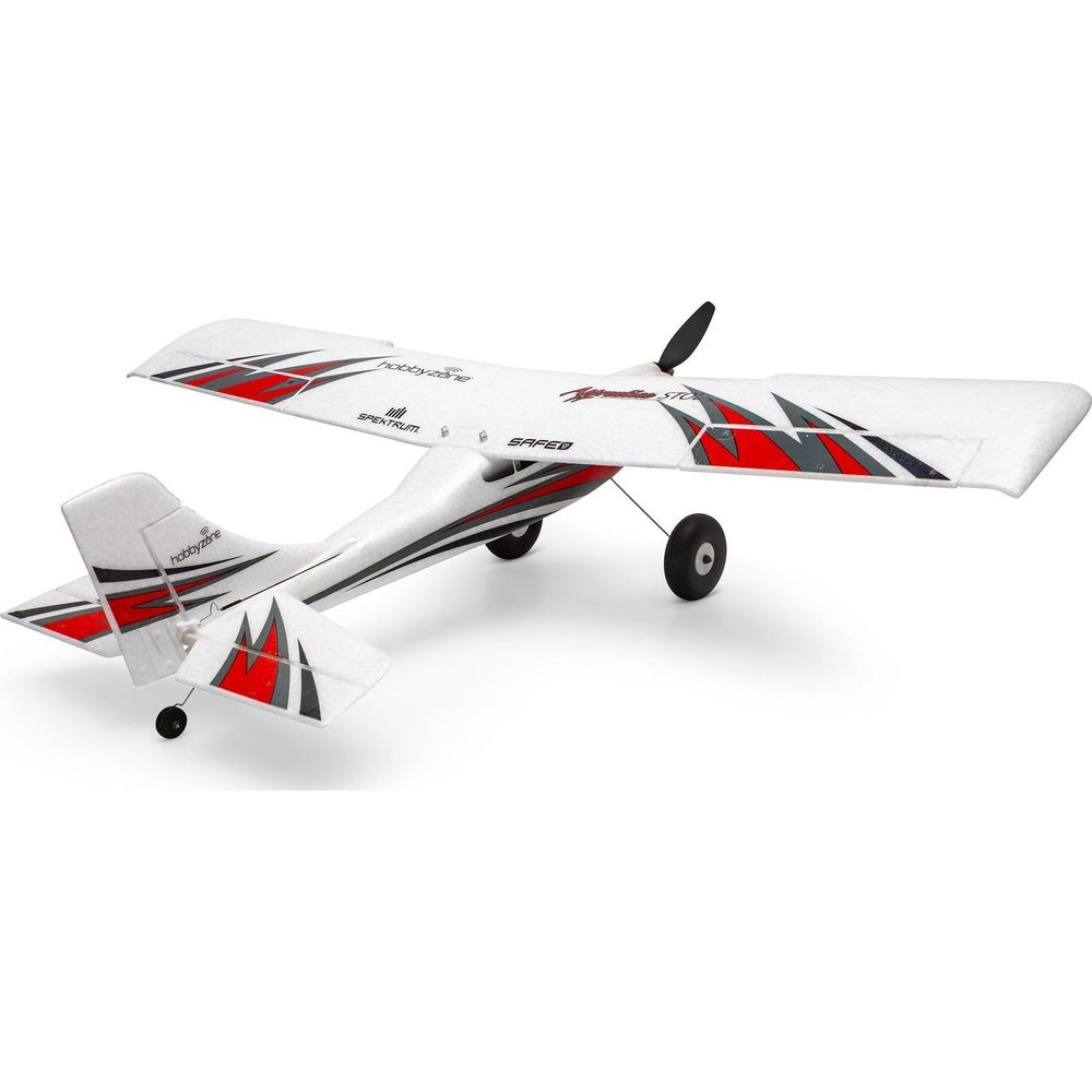 Un avion miniature blanc avec des accents rouges et gris et trois roues.