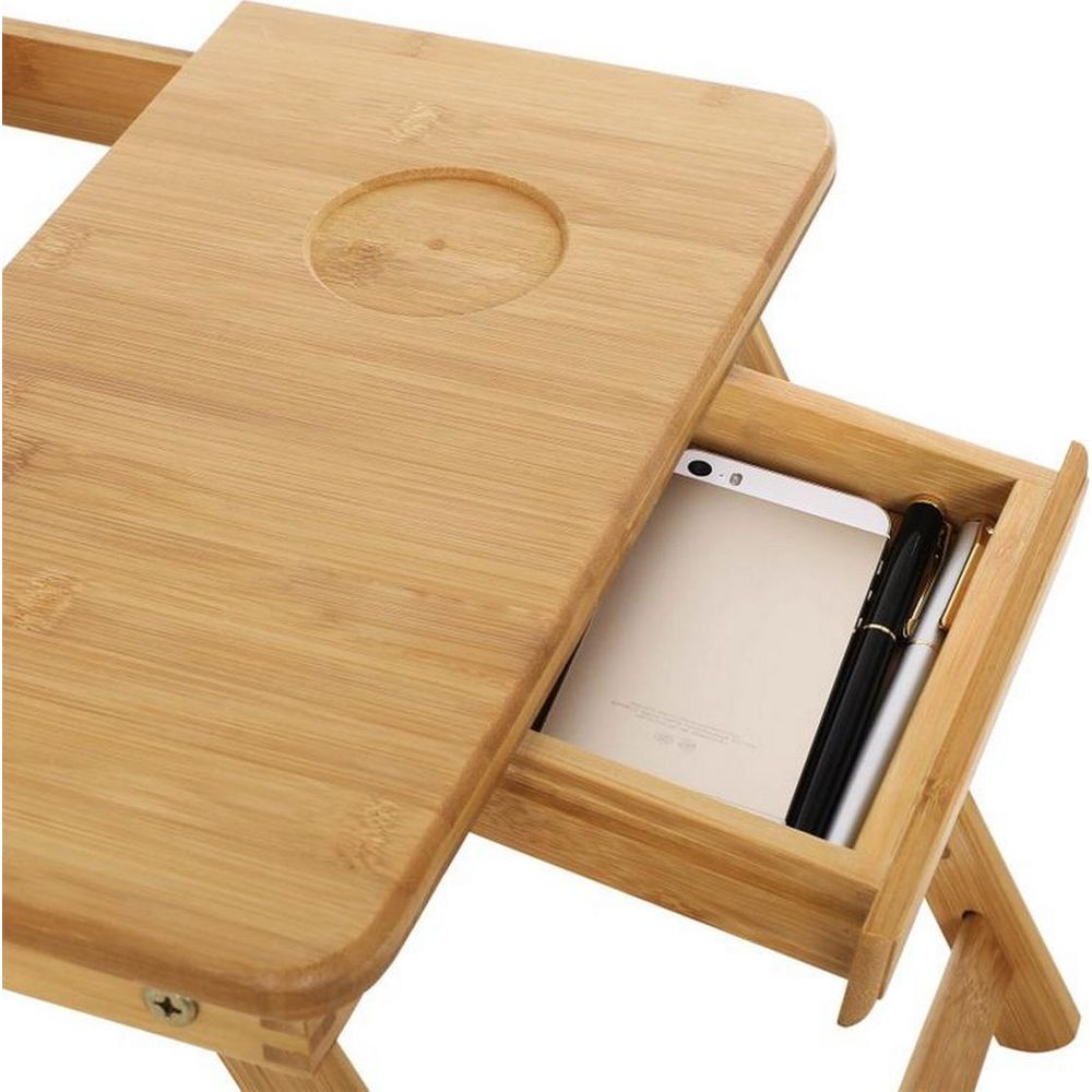 Ein hölzerner Laptop-Tisch mit einer Schublade, in der ein Handy und Stifte liegen.