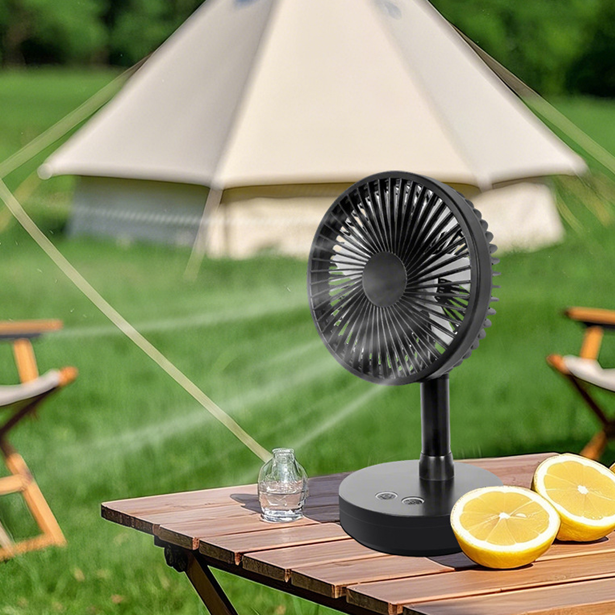 Ein schwarzer Ventilator steht auf einem Holztisch mit Zitronenhälften und einem Glas Wasser.