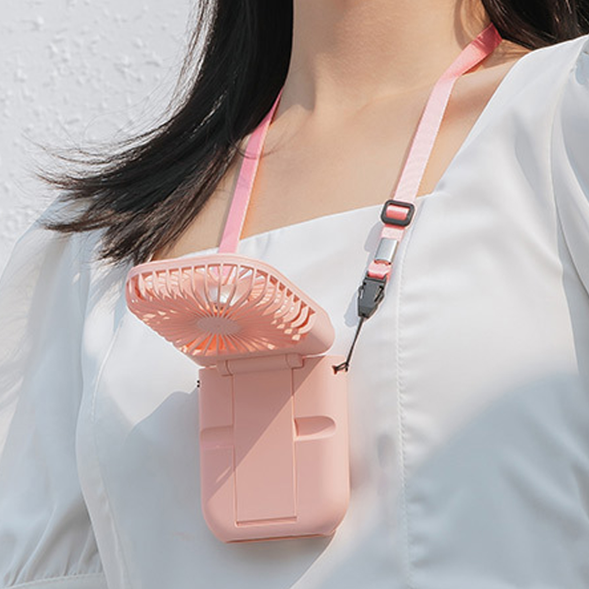 Ein rosafarbener Nackenfächer mit einem rosa Band um den Hals einer Person.