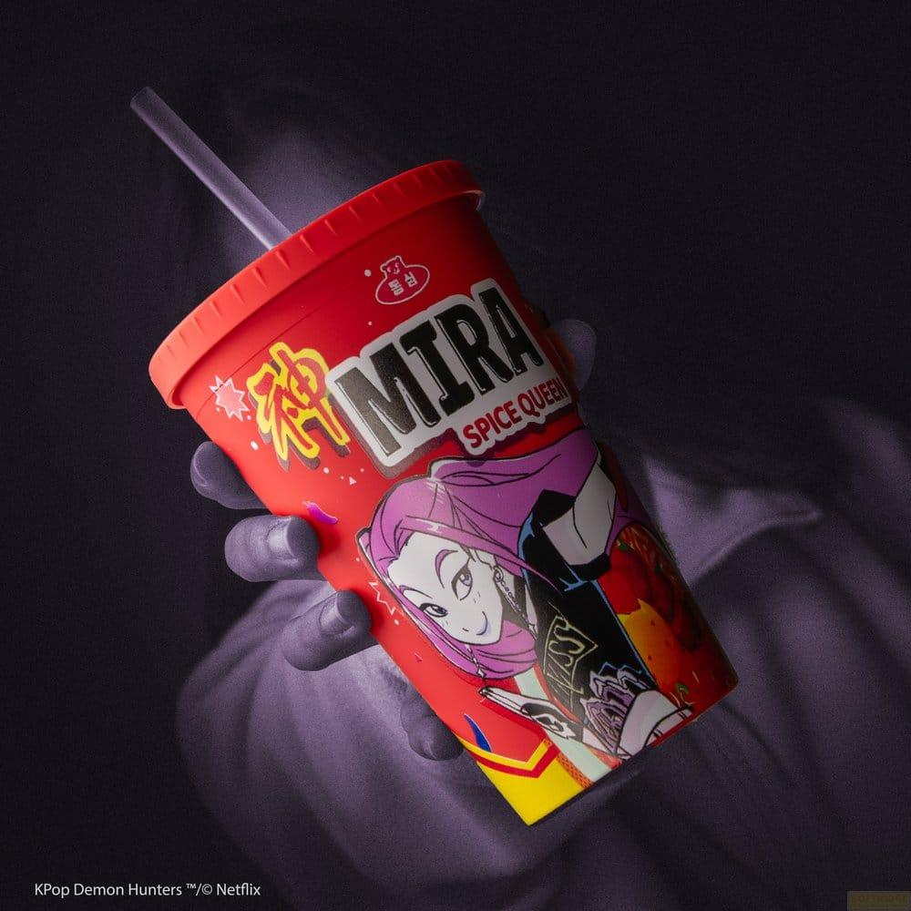Taza roja con personaje de anime y pajita, sostenida por una mano.