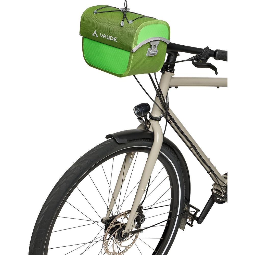 Un sac de guidon Vaude vert est attaché à un vélo beige.
