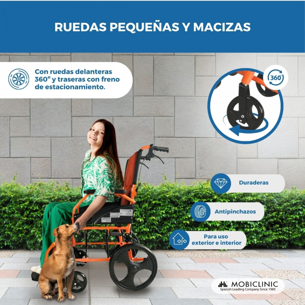 Una niña sentada en una silla de ruedas naranja junto a un perro.