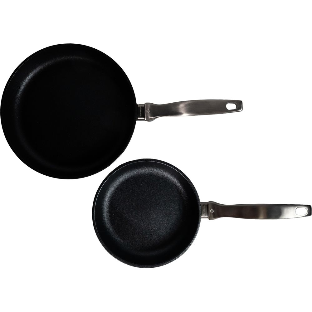 Deux poêles noires avec manches argentés, l'une plus grande que l'autre.