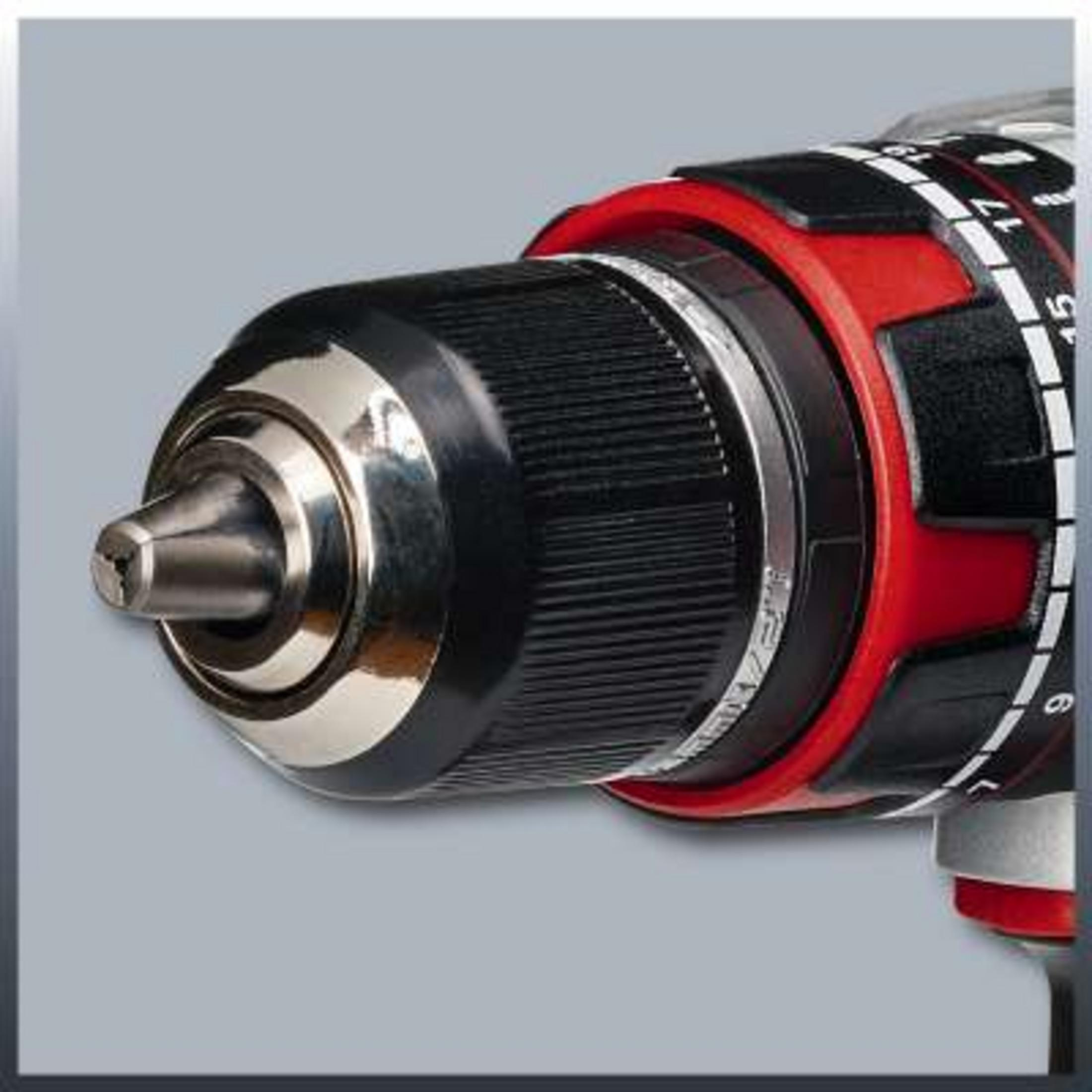 Zbliżenie uchwytu wiertarskiego z czerwonymi i czarnymi detalami i cyframi.