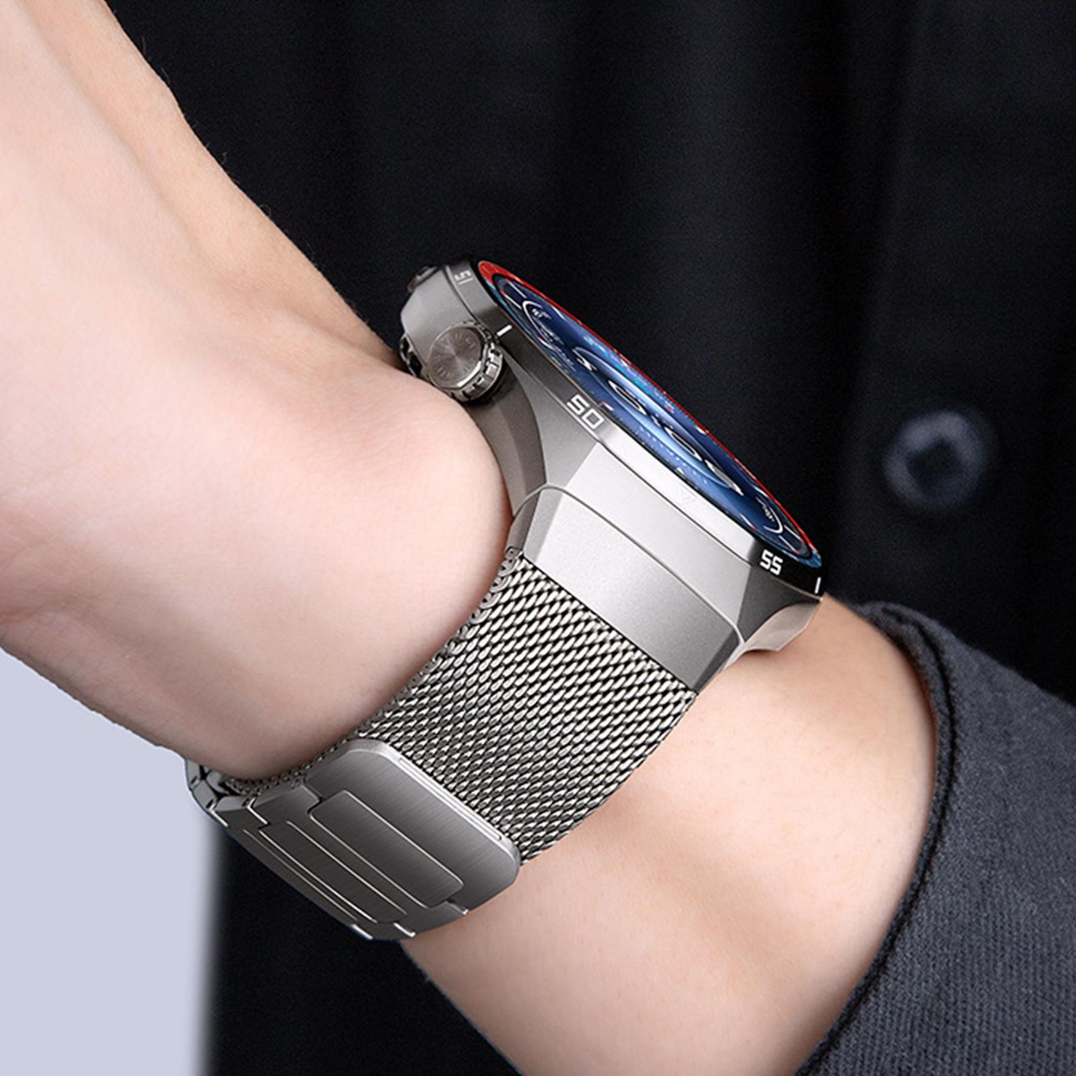 Eine Hand trägt eine silberne Smartwatch mit einem Mesh-Armband und einem blauen Zifferblatt.
