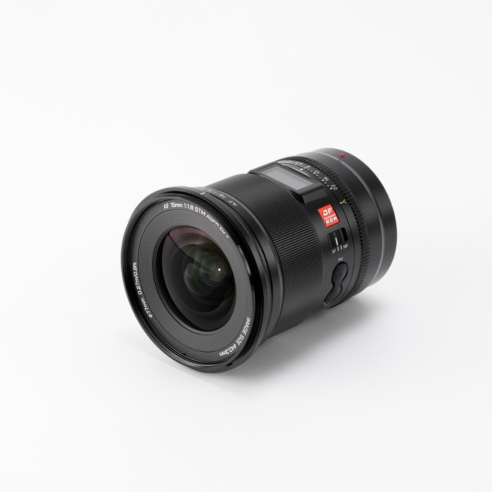 Ein schwarzes Kameraobjektiv mit AF 16mm 1:1,8 STM ASPM CU Markierungen.