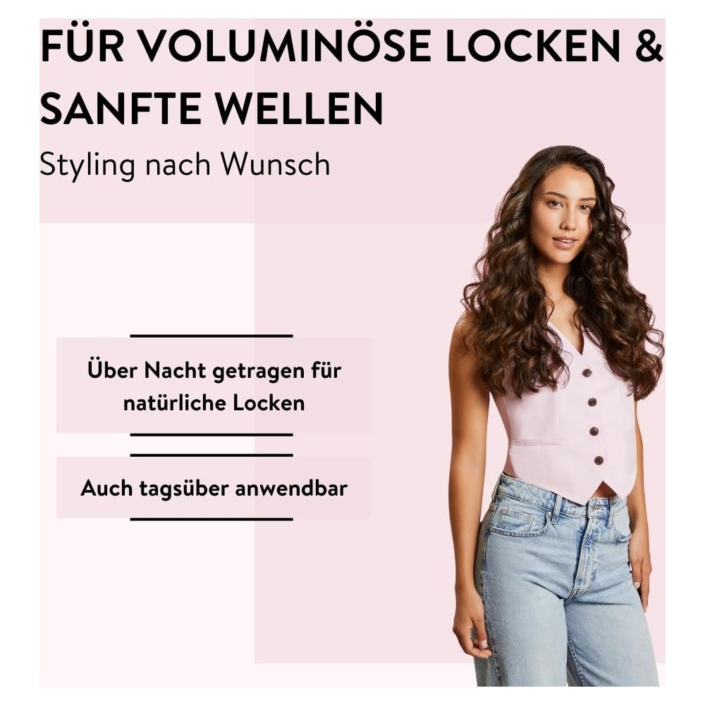 Una donna con capelli voluminosi indossa un top rosa e jeans.