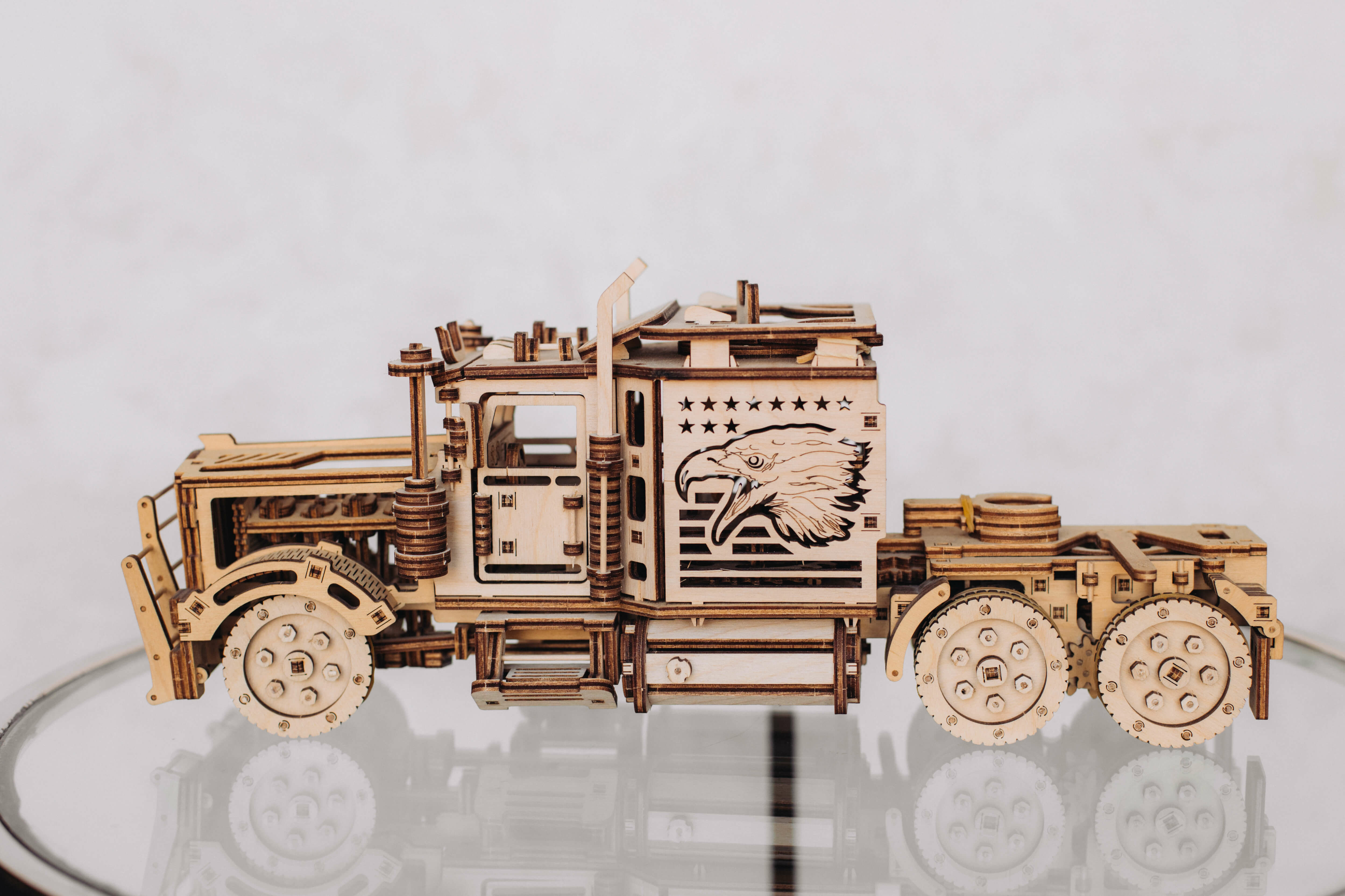 Camion modèle en bois avec tête d'aigle et étoiles sur le côté.
