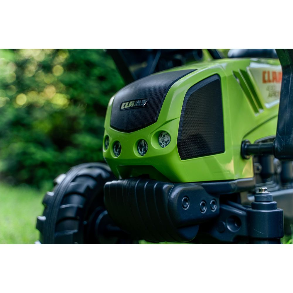Grüner Claas Traktor mit großen Rädern, im Freien auf Gras.