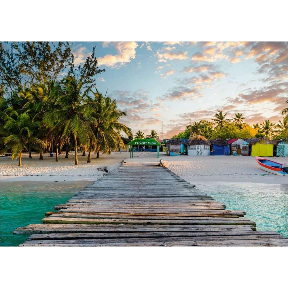 Un molo di legno conduce a capanne colorate su una spiaggia.