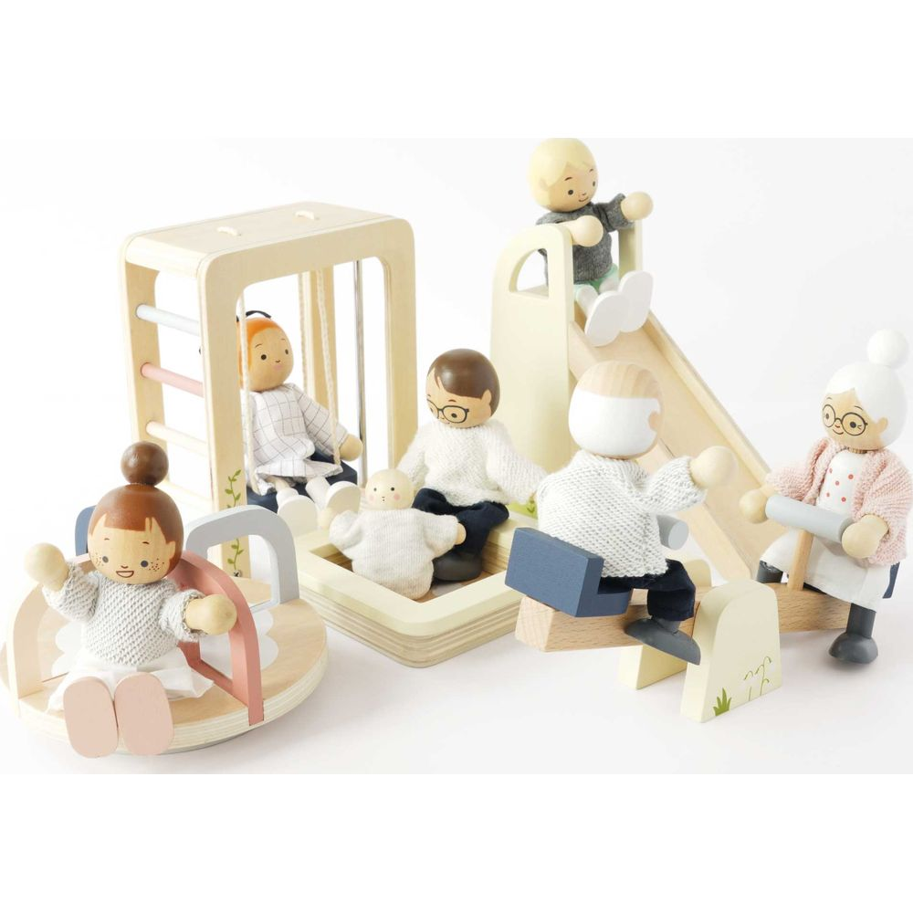 Famiglia giocattolo in legno gioca al parco giochi con scivolo e giostra.