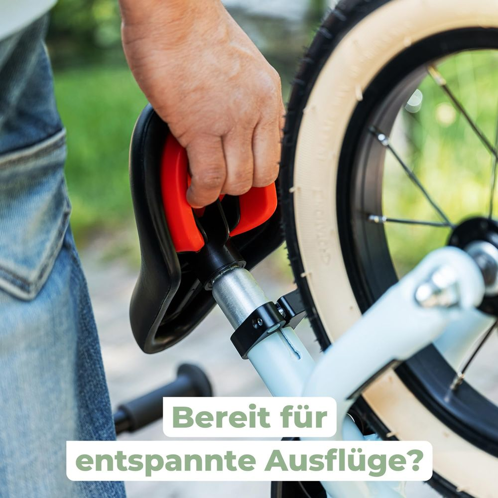Eine Hand hält einen Fahrradsitz mit roten Griffen. Bereit für Ausflüge?