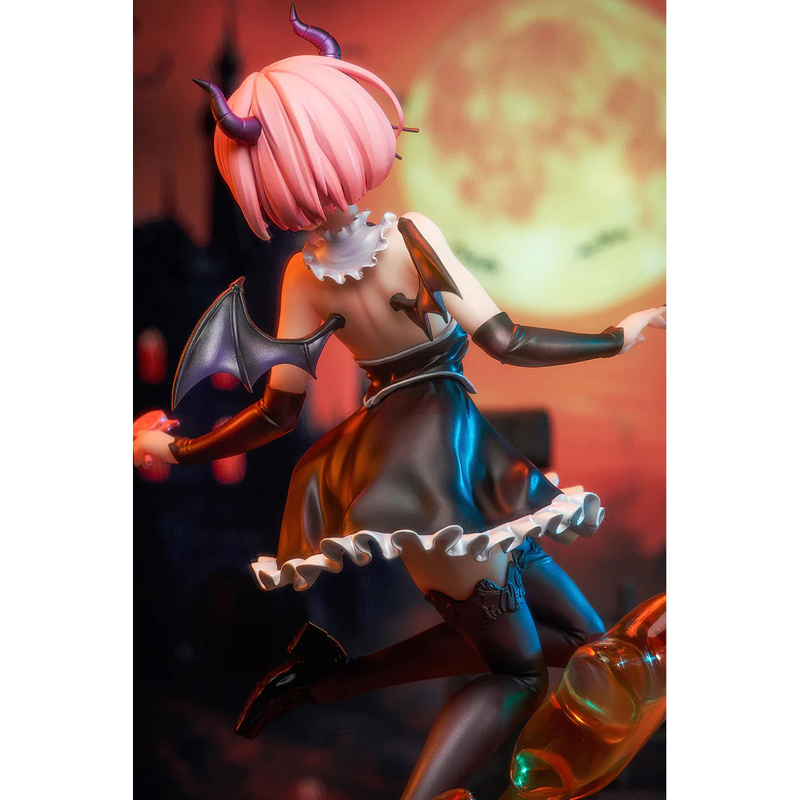Eine Anime-Figur mit rosa Haaren und Hörnern in einem schwarzen Kleid auf einem Kürbis.