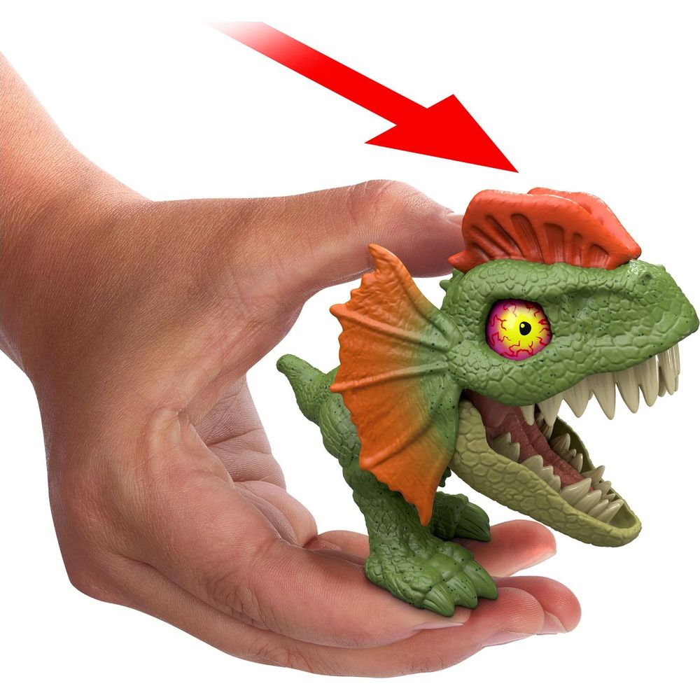 Una mano tiene un dinosauro giocattolo verde con collare arancione e occhi sporgenti.