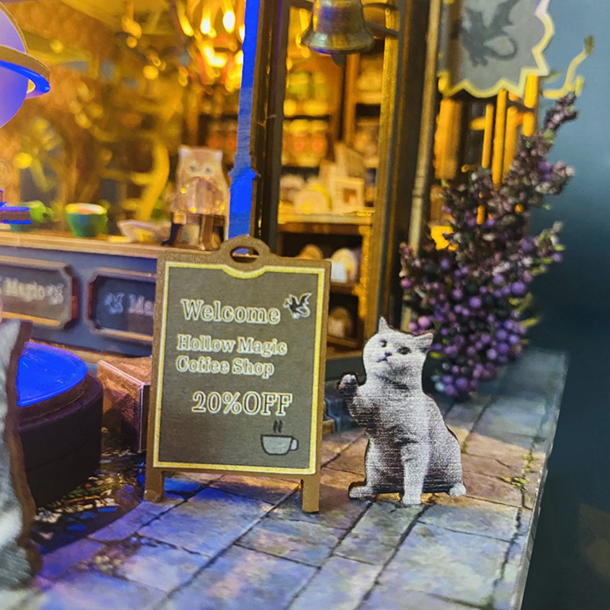 Ein Schild mit Willkommen, Hollow Magic Coffee Shop, 20% Rabatt und eine Katze.