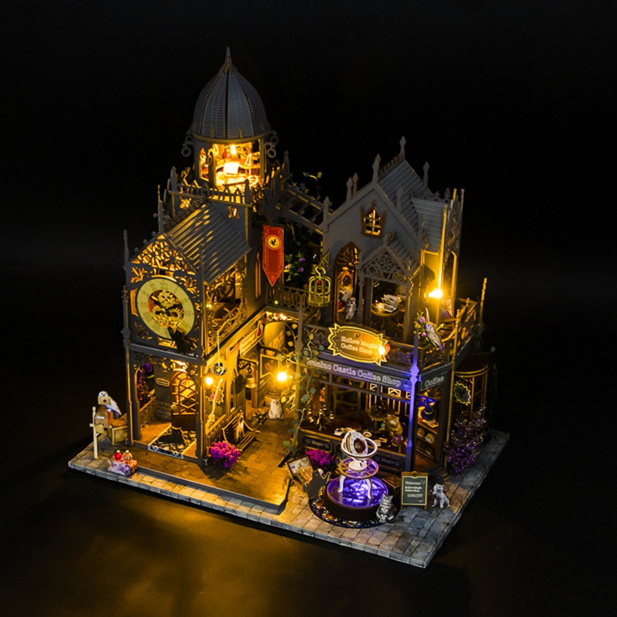 Eine beleuchtete Miniatur-Burg mit Uhr und Lichtern, detailreich gestaltet.