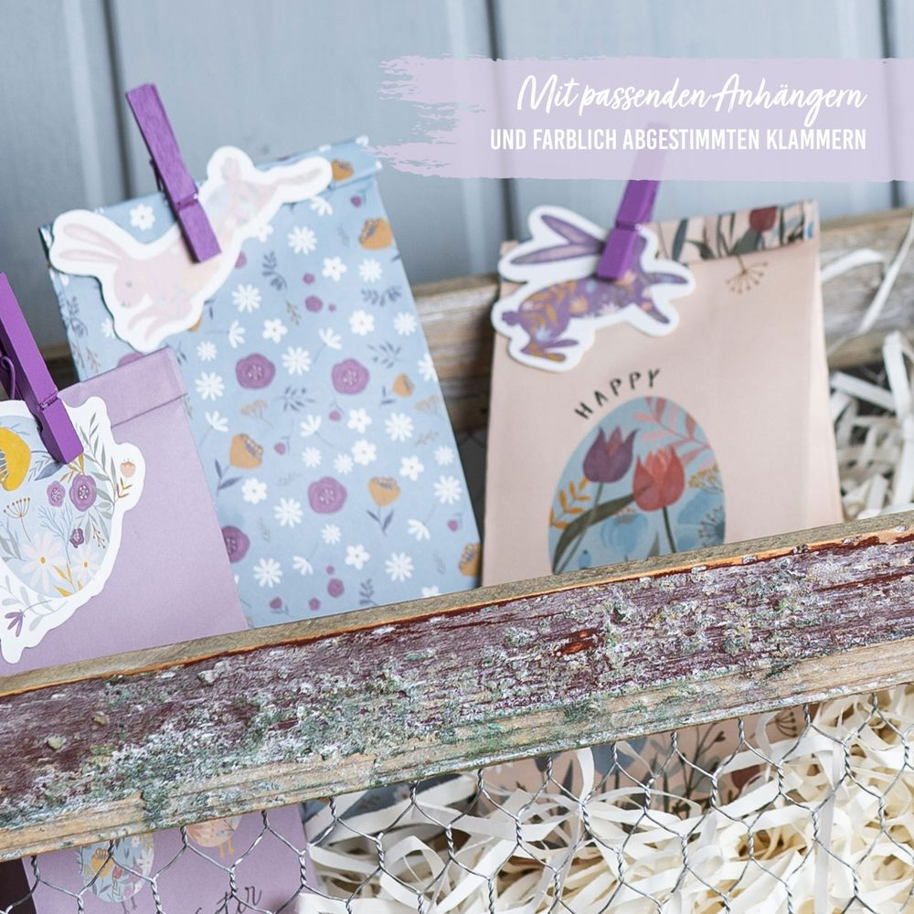 Tre sacchetti regalo di Pasqua con tag di coniglietto e clip colorate.