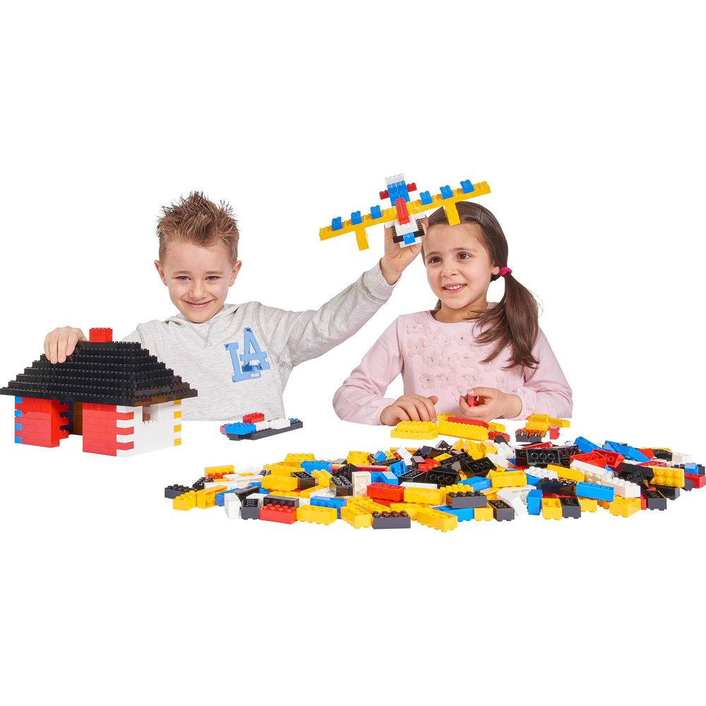 Zwei Kinder bauen mit bunten Bausteinen ein Haus und ein Flugzeug.