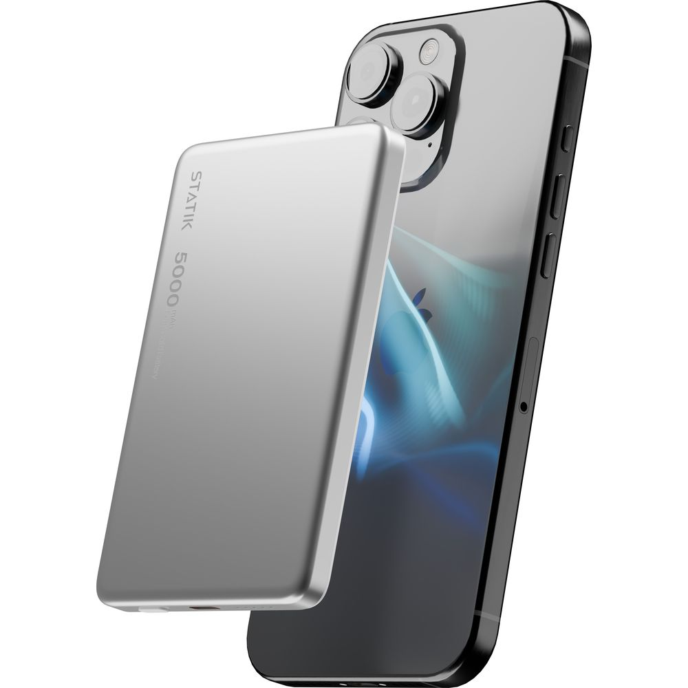 Ein silbernes Powerbank liegt vor einem Smartphone mit drei Kameras.