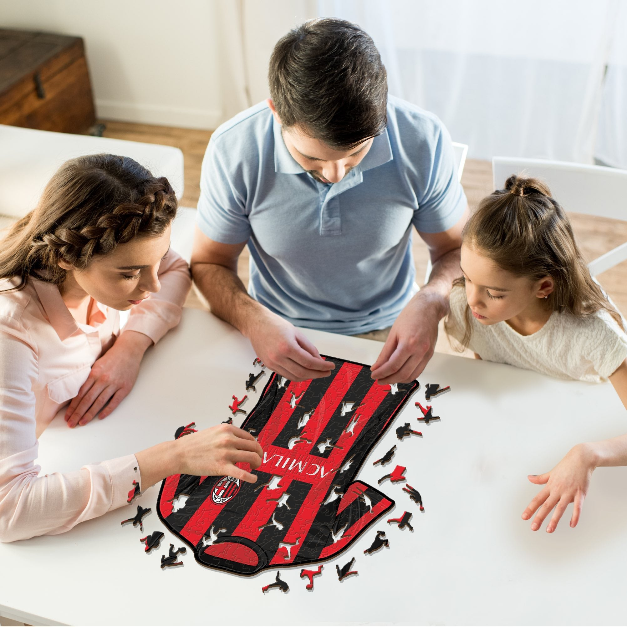 Familie zusammensetzen eines Puzzles mit Fußballtrikot-Design.