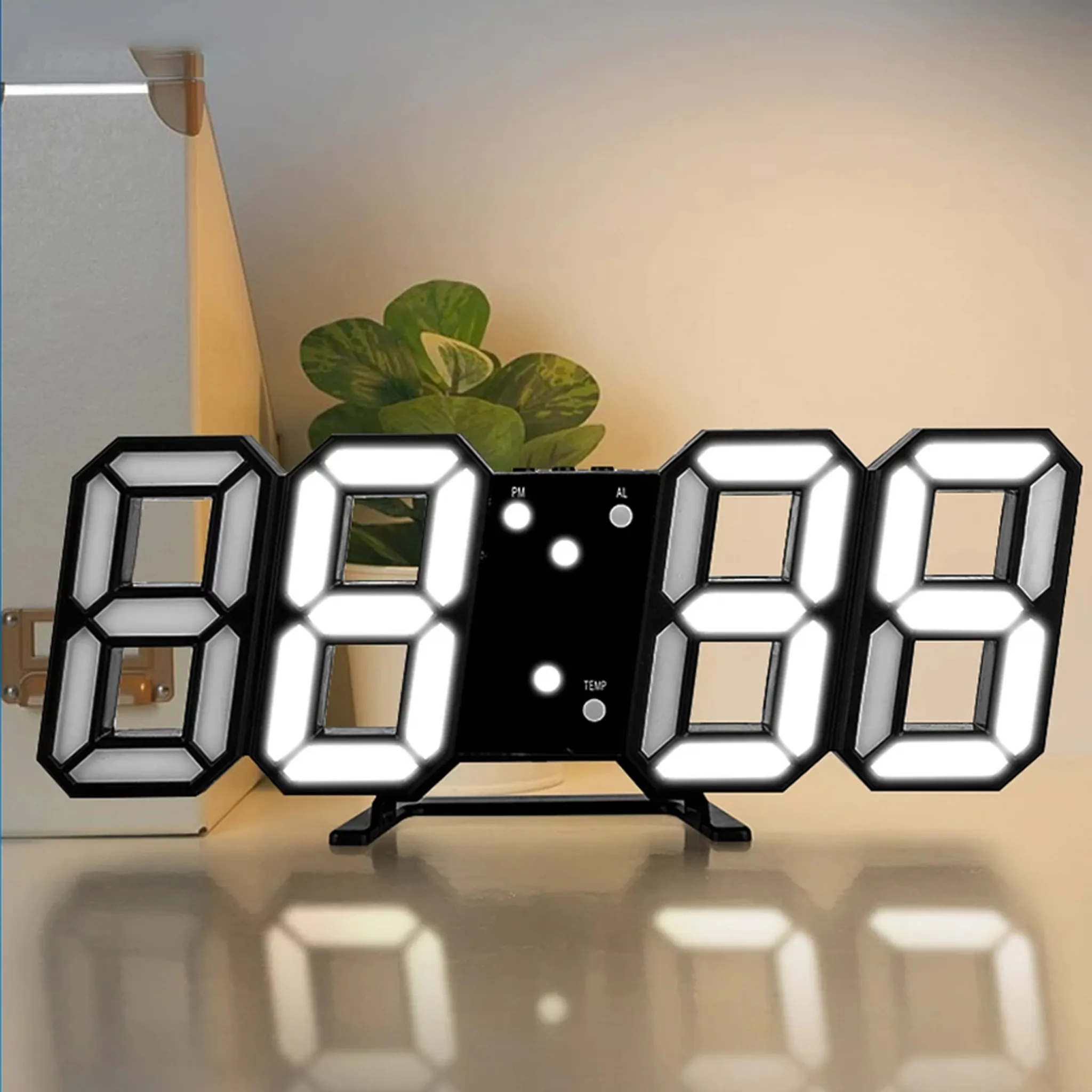 Digitaluhr mit leuchtenden weißen Zahlen auf schwarzem Hintergrund, auf einem Tisch.