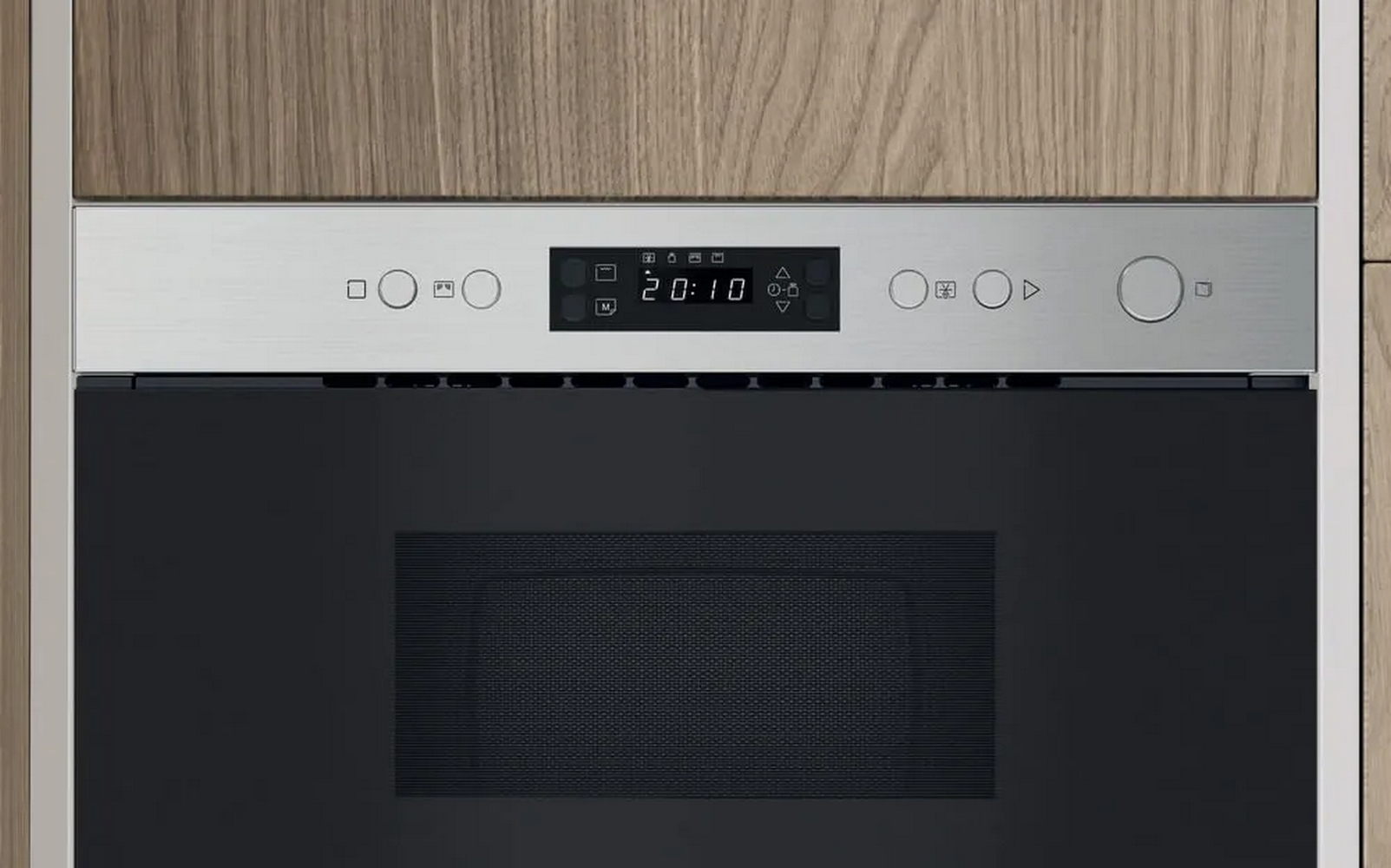 Panel de control de acero inoxidable con pantalla digital de hora y botones sobre un horno negro.