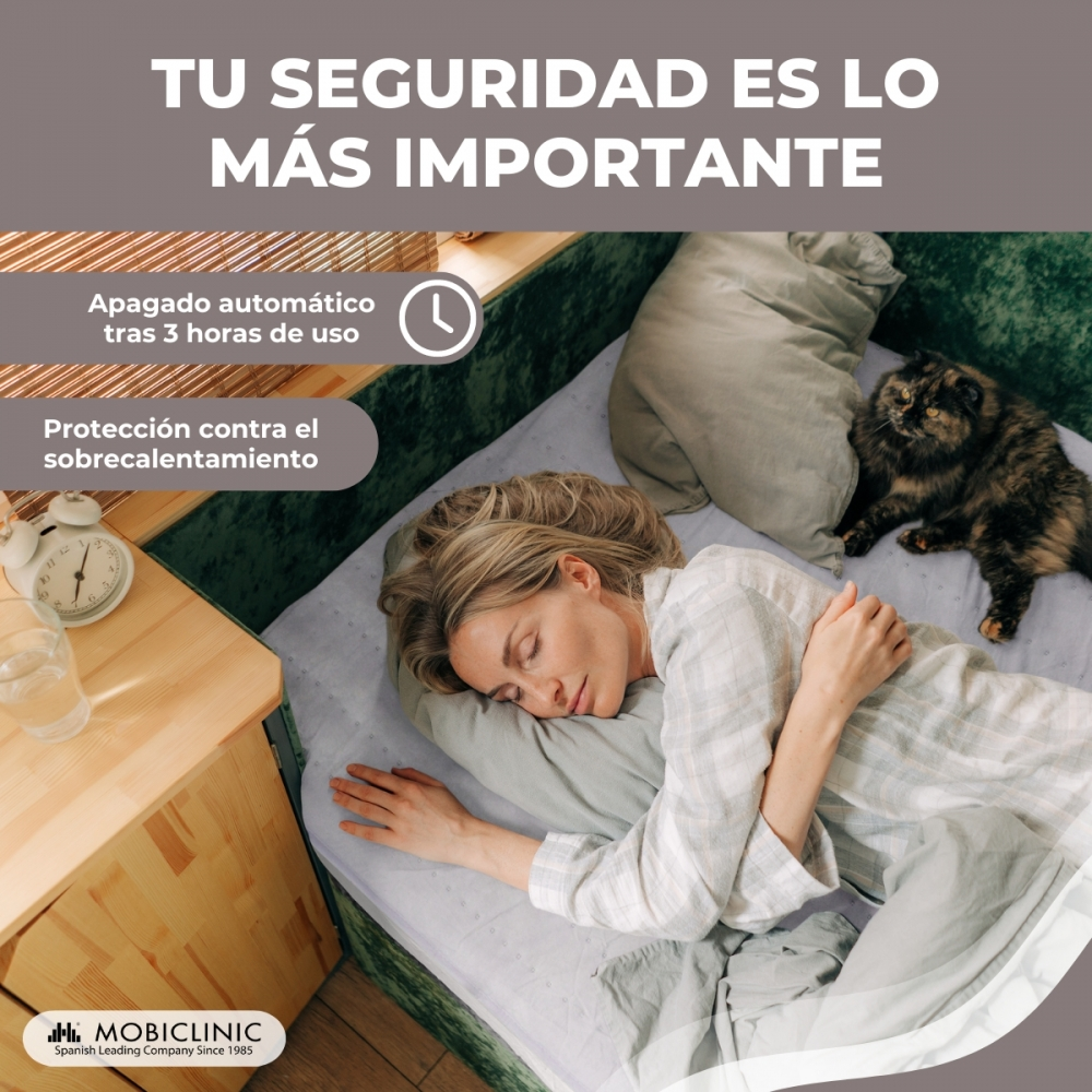 Una mujer duerme en la cama con una manta. Un gato está a su lado.