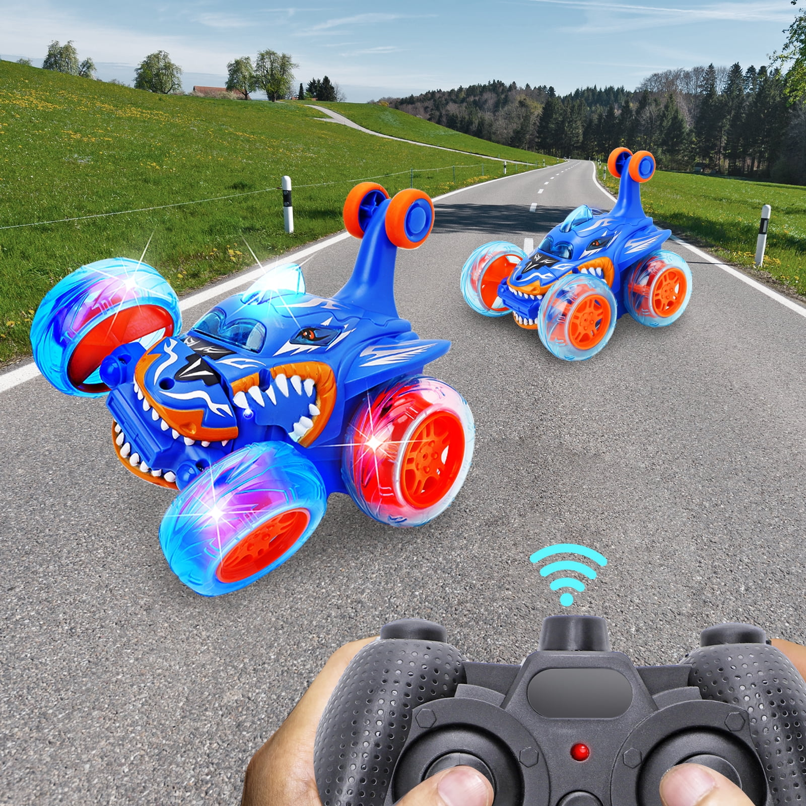 Zwei blaue Stunt-Autos mit leuchtenden Rädern fahren auf einer Straße.