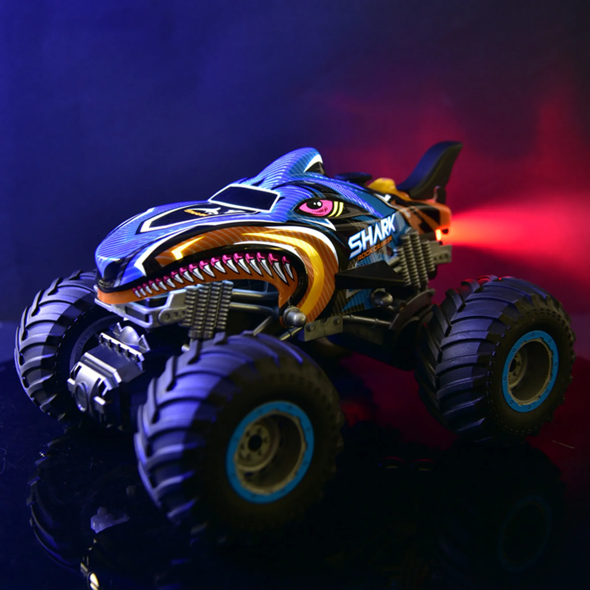Blauer Monstertruck mit Hai-Design, scharfen Zähnen und rotem Licht hinten.