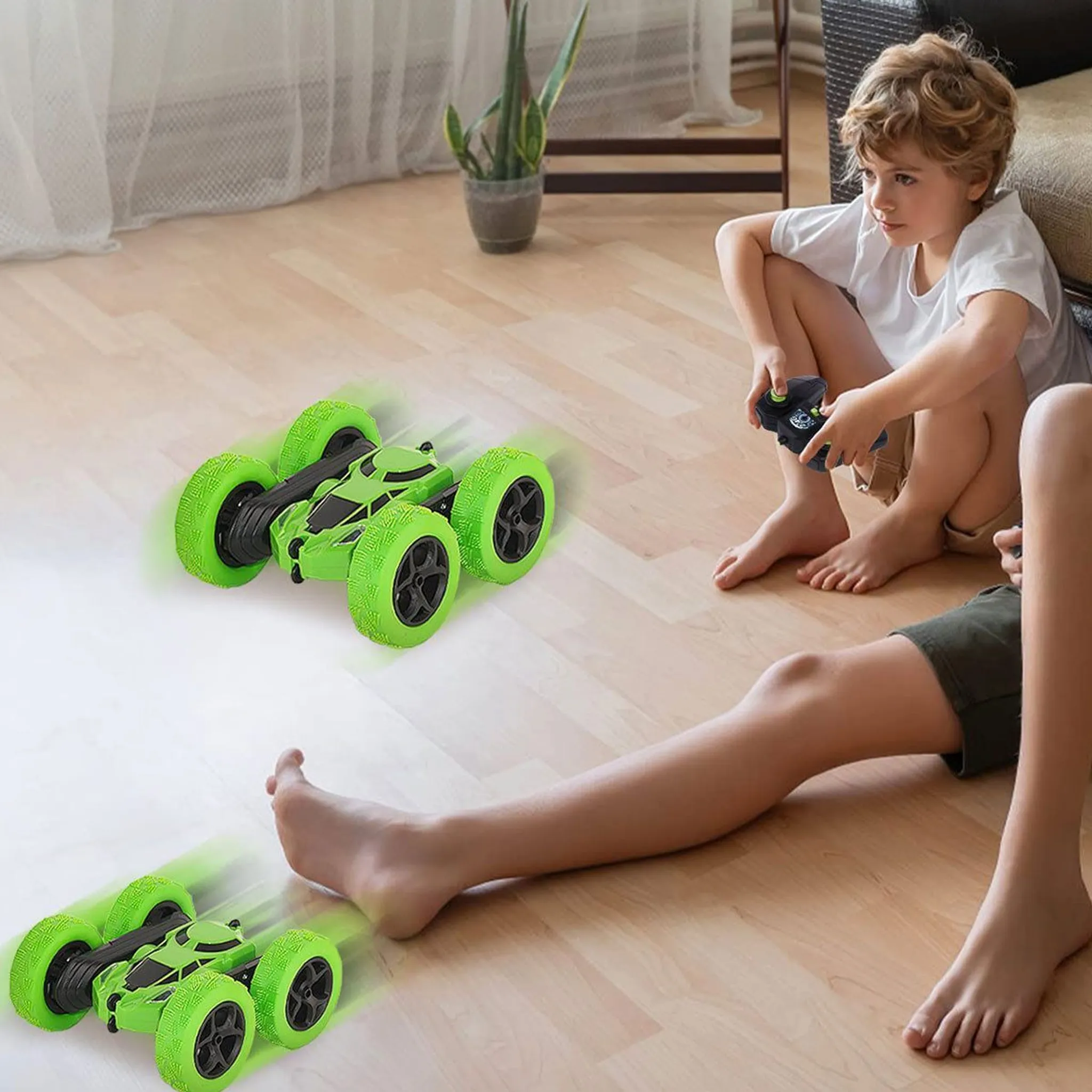 Zwei grüne ferngesteuerte Autos auf einem Holzboden, Kinder spielen.
