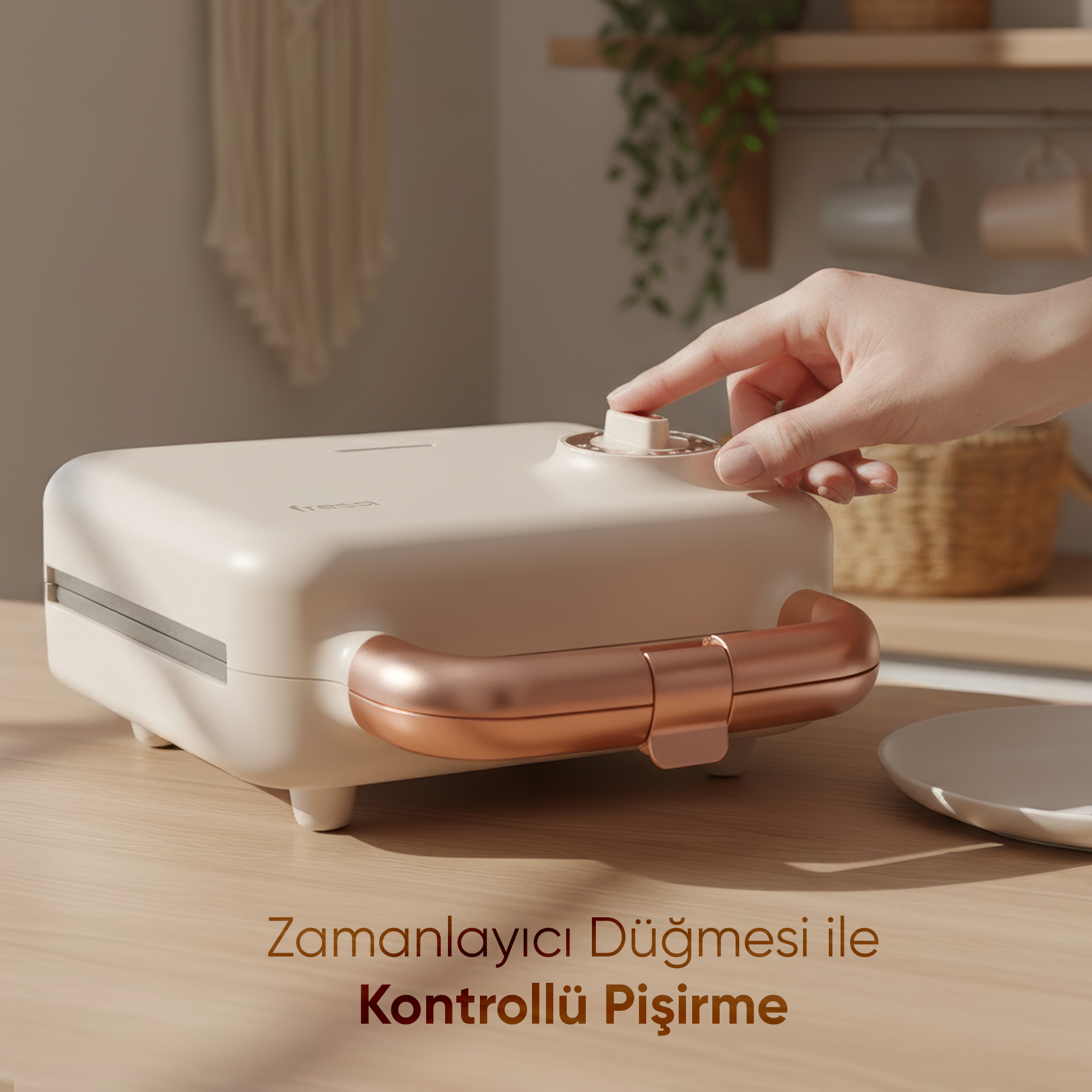 Bir el, gül altın rengi kulplu, krem rengi sandviç makinesinin düğmesini çeviriyor.